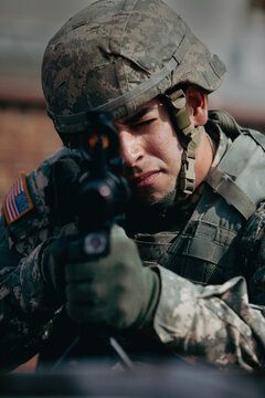 American US Army Soldier Aiming Rifle in Camouflage Uniform on Battlefield
