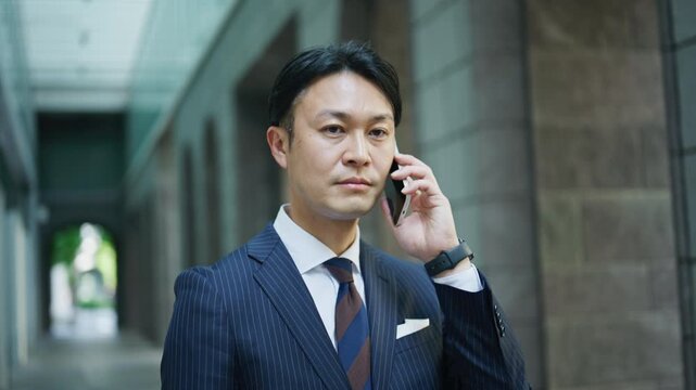 Japanese businessman on a serious phone call in an office arcade