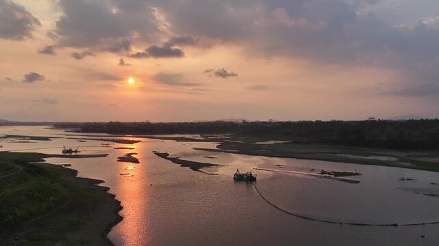 The warm sunlight creates a brilliant reflection on the water surface under a cloudy sky