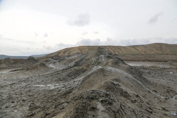 A landscape view of mud volcanoes under a cloudy sky © Wiwi Rustiana