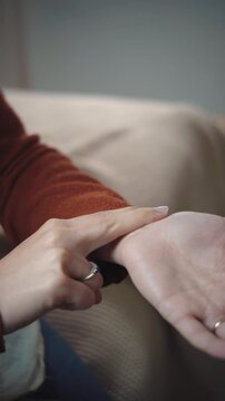 Close-up video of an anonymous woman measuring her pulse in her bedroom, illustrating health monitoring, self-care, and personal wellness.
