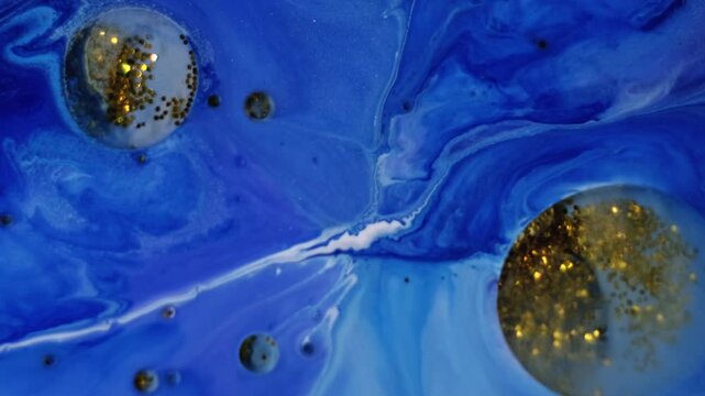 Acrylic blob. Shimmering fluid. Oil glitter spot floating on blue paint liquid surface. Art mix powder pigment fantasy abstract background.