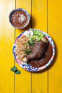 Delicious Mexican mole poblano served with rice and fresh accompaniments for a festive celebration