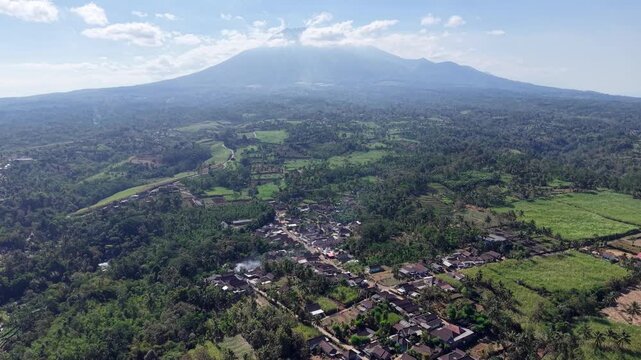 Aerial view of lush green valley below a distant mountain Kawi peak at Ngajum, Malang