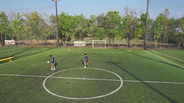 Aerial view of young boys practicing football keepie uppies on soccer field. 