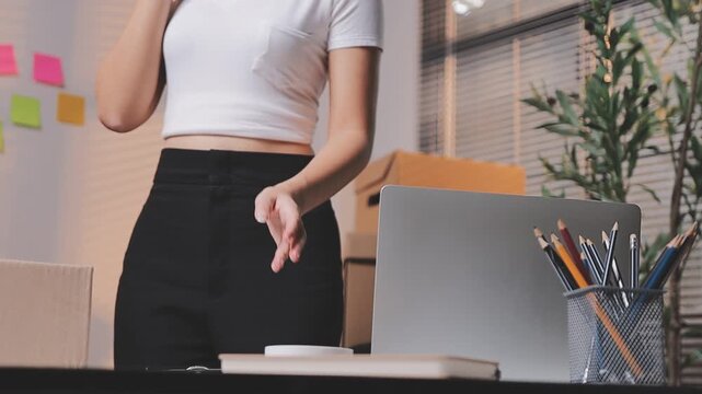Close up with Start up small business, SME female owner using laptop checking order online to prepare to pack a box of goods for sale to customers, sme business idea.