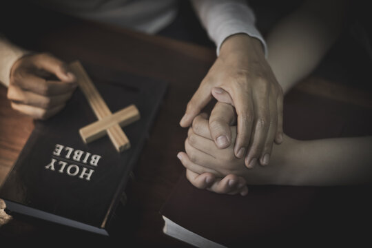 Christian Family Prayer with Praying Hands, Holy Bible and Wooden Cross for Faith, Worship, Hope and Spiritual Support.