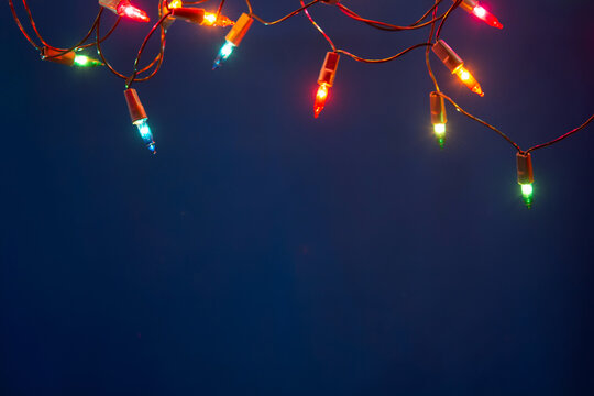 Christmas lights string on blue background with copy space