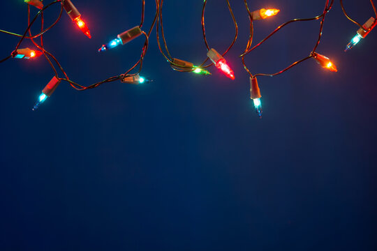 Christmas lights string on blue background with copy space
