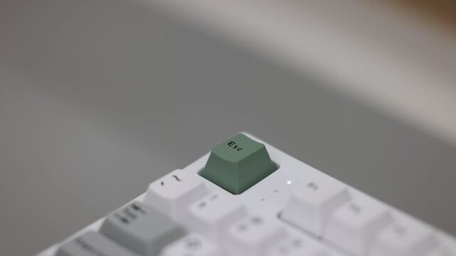 Single green keycap on a white mechanical keyboard