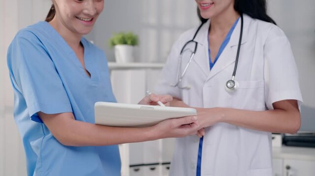 Close up of female nurse assisting doctor working in modern medical office. 