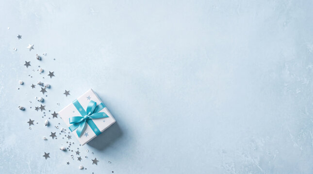 Minimal Christmas Gift Box with Blue Ribbon on Icy Winter Background with Copy Space