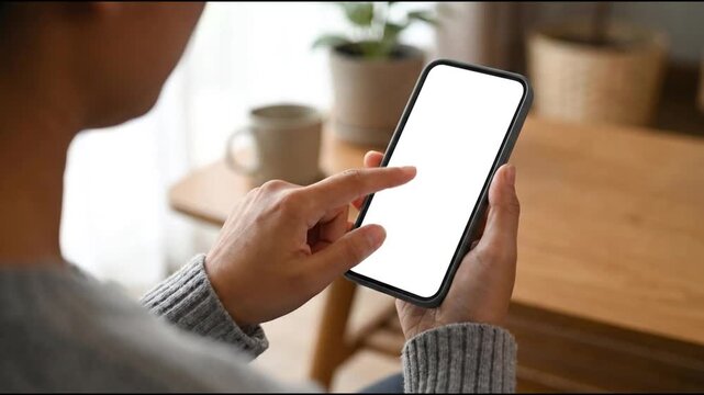 Hands rotate a blank smartphone to a vertical orientation in a cafe setting rotating device screen digital technology person indoor