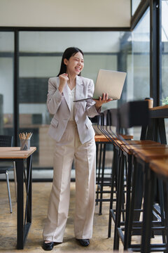 Businesswoman celebrating online success achieving professional victory