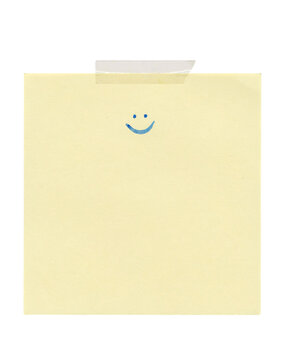 Yellow sticky note with blue smiley face and tape solated on transparent background