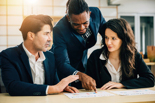 A diverse team, led by the CEO, meets to focus on research, planning, and cost analysis. Documents and graphs exemplify their teamwork and diversity. Teamwork