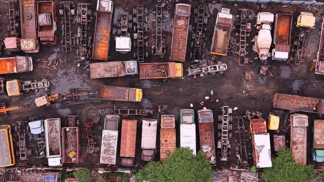 Dismantled trucks and stripped vehicle parts at salvage scrapyard aerial auto recycling industry