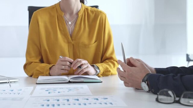 Business people discussing charts and graphs, analyzing data and collaborating on strategic project in modern corporate workspace of bright office