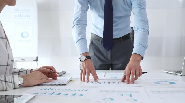 Business team professionals working together on financial reports and performance graphs during a strategy session, teamwork, planning, and corporate growth among successful people