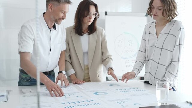 Business team collaborating and analyzing financial charts and graphs during a productive meeting in a modern office. Business people concept
