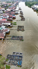 Floating fish cages arranged on the river near traditional houses in Banjarmasin, Indonesia © A Denny Syahputra