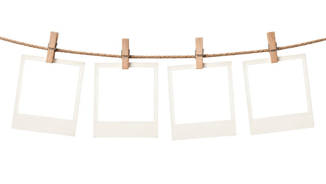 Four blank instant photo frames hanging on a clothesline isolated on transparent background