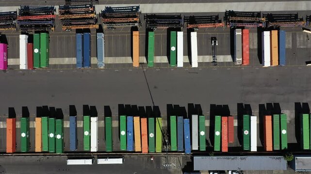 4K aerial drone footage of freight trains and rail yard in Portland, Oregon, USA, with railroad tracks, public transit bus facility, Holgate bridge and industrial transportation infrastructure