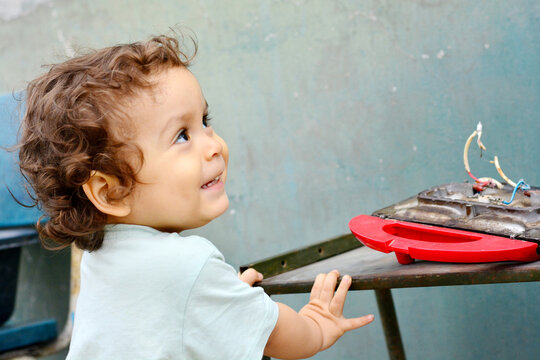 Curious toddler reaching broken appliance.