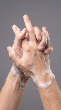 Person washing hands with thick white soap lather for hygiene