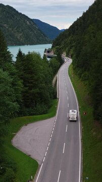 Aerial Follow Shot of White Vehicle on Scenic Achensee Lakeside Road Through Austrian Alps