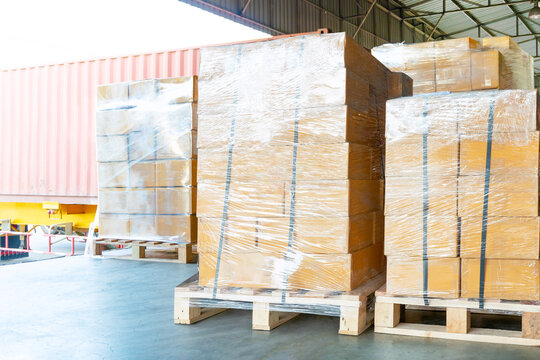 Bulk of Package Boxes Wrapped Plastic on Pallets. Truck Loading Dock Warehouse. Cardboard Boxes, Supply Chain, Goods Shipment. Distribution Warehouse Shipping Logistics	

