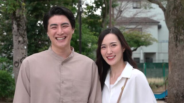 公園で笑顔のカップル30代日本人　カメラ目線