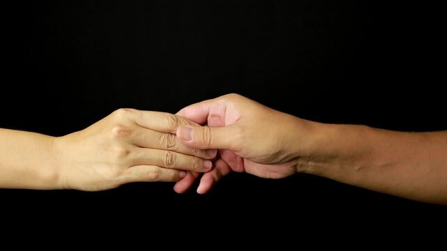 Slow Motion Close Up of Two Hands Slowly Letting Go and Separating on Black Background
