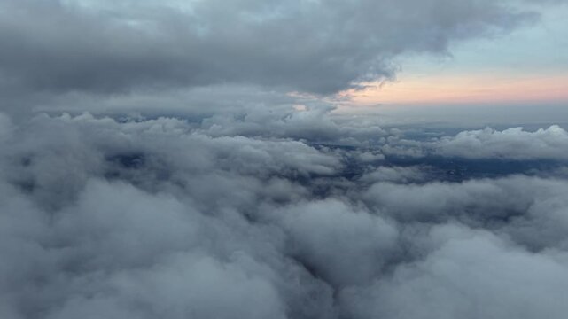 Sky filled with thick, rolling clouds. Dramatic hues of twilight glow beneath the storm at Pronojiwo, Lumajang