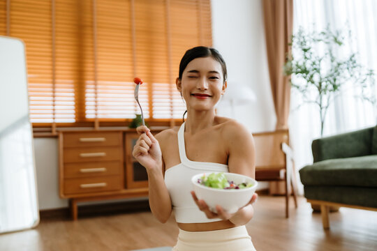 Healthy Asian Woman Enjoying Fresh Salad at Home After Yoga Workout