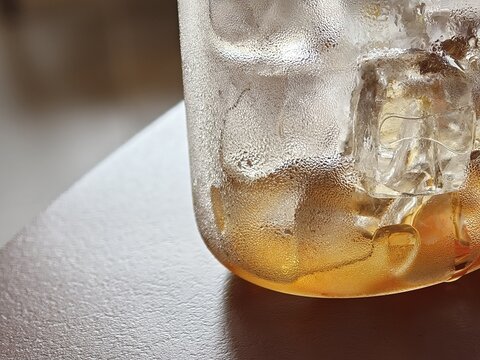 Amber Iced Drink With Melting Ice Cubes Closeup