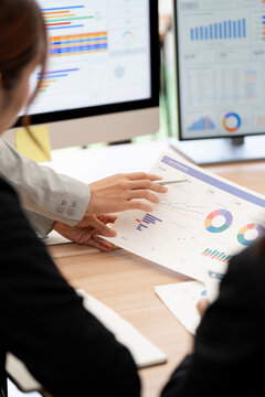 Business People Pointing at Financial Charts on Desk in Office