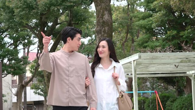 公園を歩くカップル30代日本人