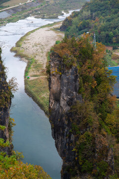 Majestic Vertical Limestone Standing Rock Rising Abruptly Above River Bend