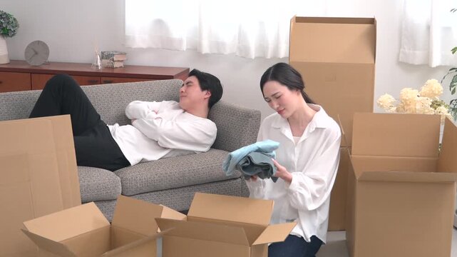 引っ越し作業中に怠ける男性と疲れている女性