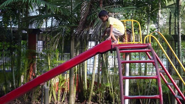 Young child playing on colorful playground slide outdoors
