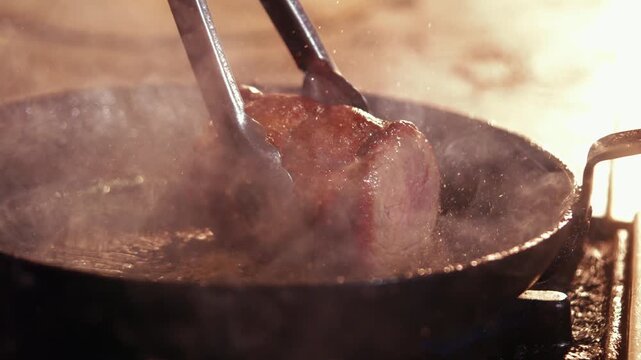Sizzling sausages cooking in a cast iron skillet with a spatula