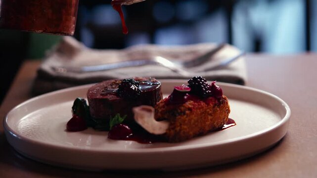 Close-up of gourmet beef dish with black caviar and cranberry sauce