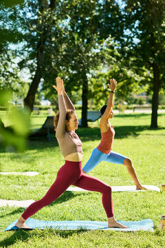 Vertical shot of Caucasian young adult woman and companion practicing yoga in park. Fitness concept suitable for wellness marketing and health advertising campaigns