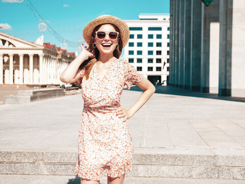 Young beautiful smiling hipster woman in trendy summer clothes. Sexy carefree woman posing on the street background at sunset. Positive model outdoors. Cheerful and happy in sunglasses and hat