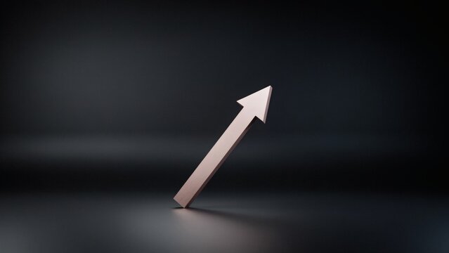 A metallic arrow pointing diagonally upward against a dark and moody minimalist studio background surface with pointing toward upper right corner frame
