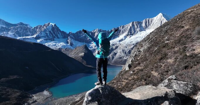Backpacking woman hiking on high altitude mountain top