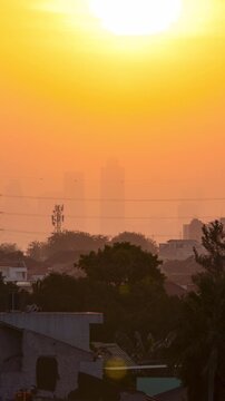 Vertical video - Timelapse of the sun setting behind Jakarta skyline and covered by heavy air pollution