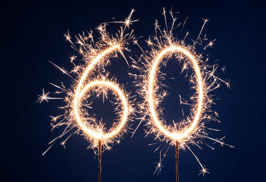 Sparkler fireworks forming number sixty celebration display against night sky