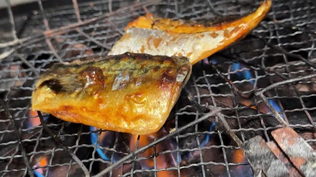 Grilled Fish over Fire: Salted Mackerel (Saba Shioyaki) on a Wire Mesh above a Blue Gas Flame, Traditional Japanese Food